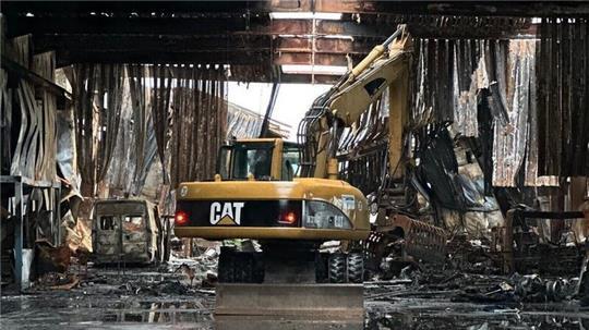 Abrissarbeiten nach Großbrand: Ein Bagger räumt die Überreste der zerstörten Lagerhalle in Lamstedt.