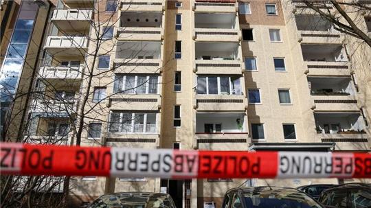 Absperrband der Polizei hängt nach dem Brand im Leipziger Stadtteil Paunsdorf vor dem Plattenbau.