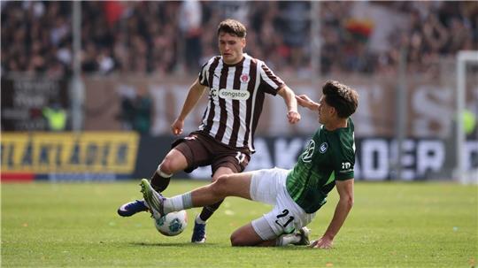 Abstiegskampf pur: Der Wolfsburger Joakim Maehle packt die Grätsche gegen St. Paulis Arkadiusz Pyrka aus.