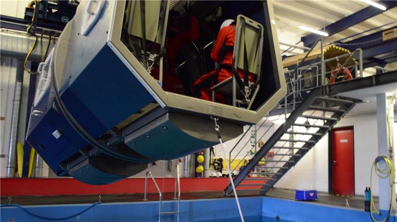 Vom Überleben auf rauer See: So hart ist das Offshore-Training in Bremerhaven Abwärts: Bei einem Überlebenstraining für Offshore-Fachkräfte in Bremerhaven ist der Hubschrauber-Simulator an einer Winde über ein Schwimmbecken gezogen worden. Dann fährt er auf das Kommando „Ditching, Ditching, Ditching“ des Ausbilders abwärts. Foto: Saure