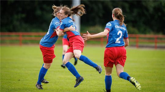 Drei Frauen des FC Oste/Oldendorf jubeln auf dem Platz.