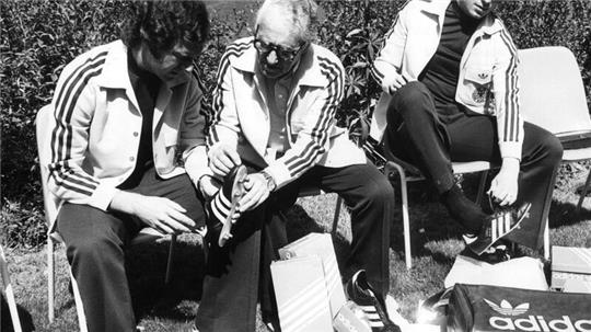 Adi Dassler (Mitte) galt lange Zeit als Pionier der Sportschuh-Welt. Das von ihm gegründete Unternehmen Adidas wird 75 Jahre alt. (Archivbild)