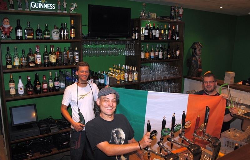 Admiral Nelson wacht über sie: Gastronom Tim Franz zapft in seinem neuen Irish Pub „The Rebel’s Choice“ am Ostfleth in Buxtehude, Torben Gerschau (links) und Lars Laengner helfen bei der Vorbereitung. Foto Vasel