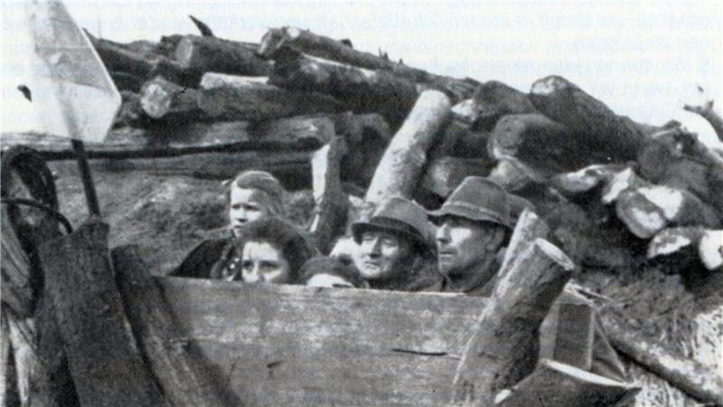 Kampflose Kapitulation: Wie Wesermünde dem Krieg entkam Ängstlich-sketische Blicke: Hinter Holzstämmen verborgen warteten Menschen auf den Einmarsch der alliierten Truppen. Der Schnappschuss stammt von einem britischen Kriegsberichterstatter.