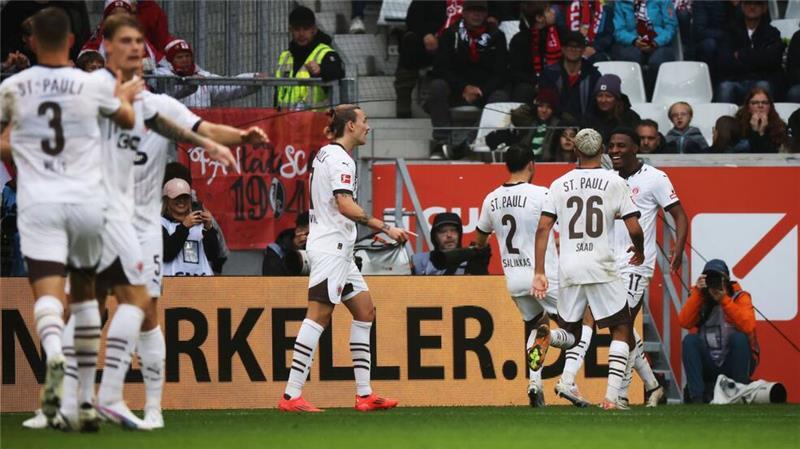 Erster Bundesliga-Sieg seit 13 Jahren: St. Pauli erleichtert Afolayan jubelt nach dem 2:0 mit seinen Mitspielern.
