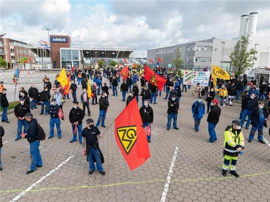 Airbus-Beschäftigte in Hamburg-Finkenwerder demonstrieren im Mai 2021 vor den Toren des Werksgeländes. Die Verhandlungen zwischen Airbus und der IG Metall über den seit Monaten umstrittenen Konzernumbau gehen in die zweite Runde. Foto: Daniel Reinhardt/dpa
