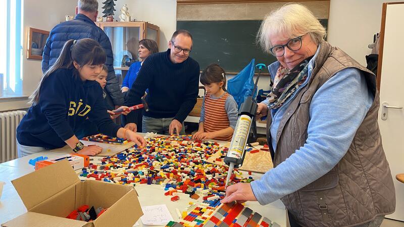 Aktion für einen barrierfreien Zugang: Elisa, Mattis und Carla bauen zusammen mit ihrem Papa Christian Marquardt und Hedwig Sarrazin Rampen aus Legosteinen.