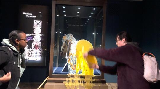 Aktivisten beschmieren die Vitrine, in der die Krone ist.