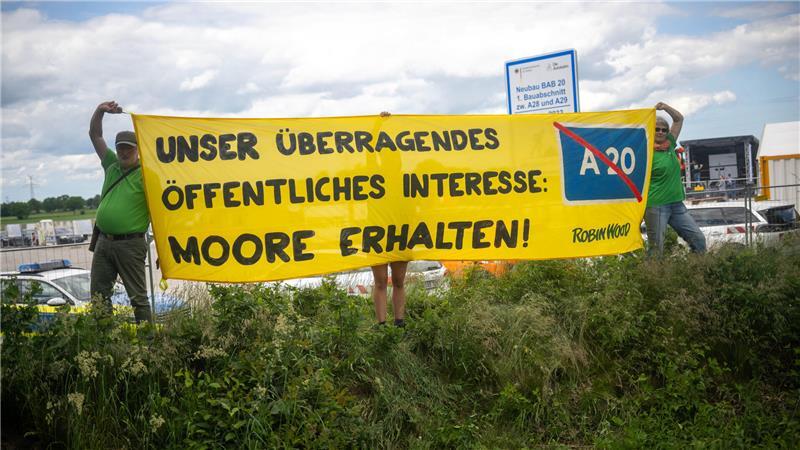 Aktivisten mit Plakaten zum Moorschutz.