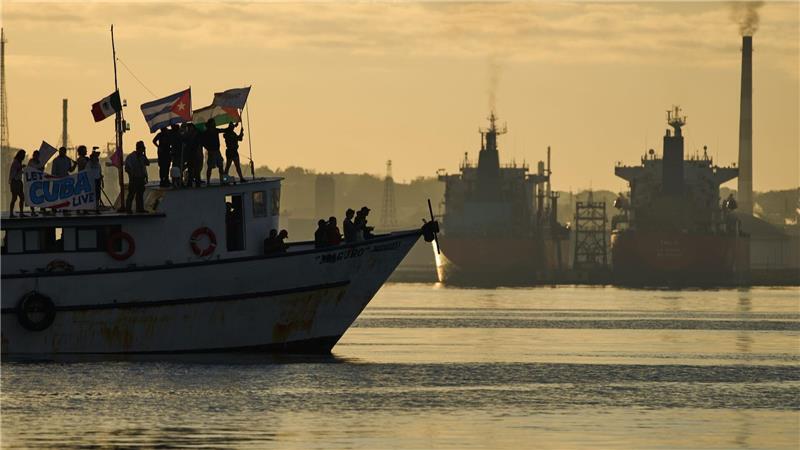 Aktivisten schwenken kubanische und palästinensische Fahnen auf dem Schiff „Maguro“, das im Rahmen des Konvois „Nuestra America“ (Unser Amerika) aus Mexiko mit humanitärer Hilfe eintrifft, in der Bucht von Havanna.