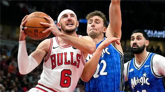 Alex Caruso (l) von den Chicago Bulls zieht zum Korb, während Franz Wagner von den Orlando Magic verteidigt.