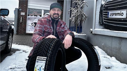 Alexander Bauer mit Winterreifen und Ganzjahresreifen. Das EU-Reifenlabel zeigt, wie sie bei Kraftstoffverbrauch, Nassbremsen und Lautstärke abschneiden.