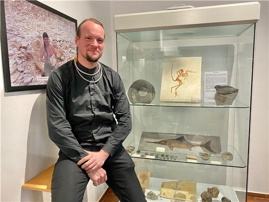 Alexander Benn an einer Vitrine mit Originalen und Repliken von berühmten Funden, darunter ein Urvogel und ein Fischsaurier. Fotos: Lepél
