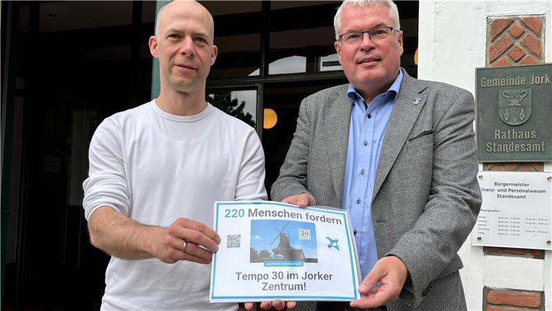 Alexander Schöcke (links) überreicht die Petition an Jorks Bürgermeister Matthias Riel. Schöcke möchte erreichen, das zwischen Osterjork und Westerjork zukünftig Tempo 30 gilt.