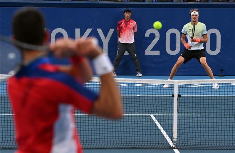 Alexander Zverev (rechts) und Novak Djokovic beim Ballwechsel. Foto: Marijan Murat/dpa