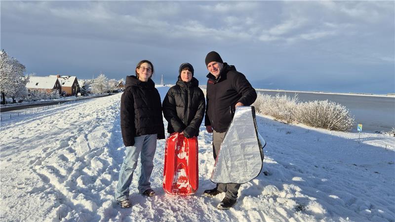 Jede Menge Spaß im Schnee: Mit Schlitten und Bob den Deich hinunter Alimi (rechts) mit seinen Kindern Semija und Hazier haben Spaß mit ihrer Autofront-Matte.