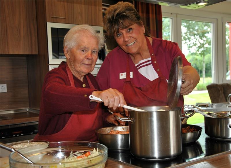 Alltag in der Wohngruppe im Seniorenhaus: Zusammen mit der Bewohnerin Maria Weiß (links) kocht Präsenzkraft Silvia Schönmann das Mittagessen .