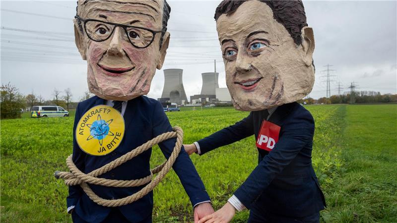 Als Bundeskanzler Friedrich Merz (l) und SPD-Vorsitzender Lars Klingbeil verkleidete Atomkraftbefürworter demonstrieren gegen die Sprengung.