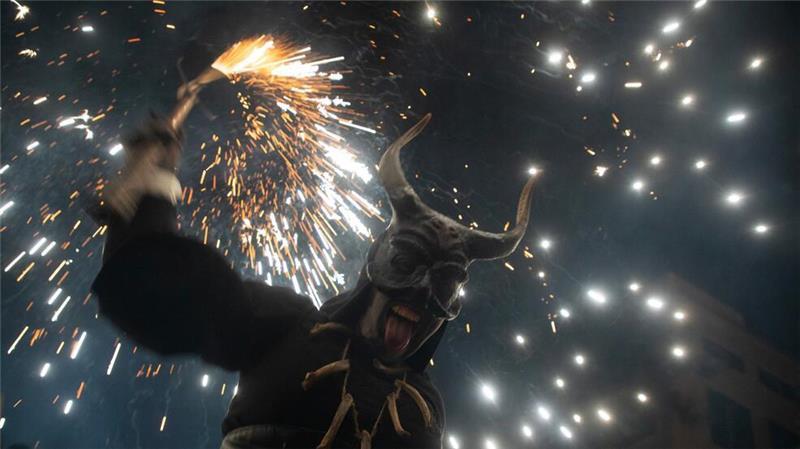 Als Teufel verkleidete Menschen feiern mit Feuerwerkskörpern bei der traditionellen Veranstaltung Correfoc (Feuerlauf) auf Mallorca.