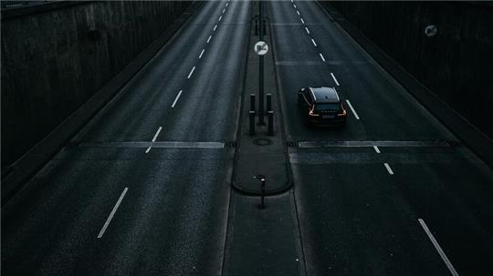 Ein Auto fährt nachts über eine Straße.