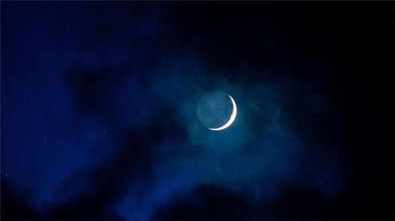 Als schmale Sichel scheint der Mond am Abendhimmel über Mecklenburg-Vorpommern hinter einer Wolkenlücke hervor. 