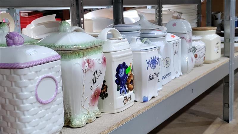 Dirk und Marinas Flohmarkthalle in Stade: Ein Paradies für Trödel-Fans Alte Porzellan- und Keramikdosen für Reis, Kaffee und Mehl stehen aufgereiht im Regal.
