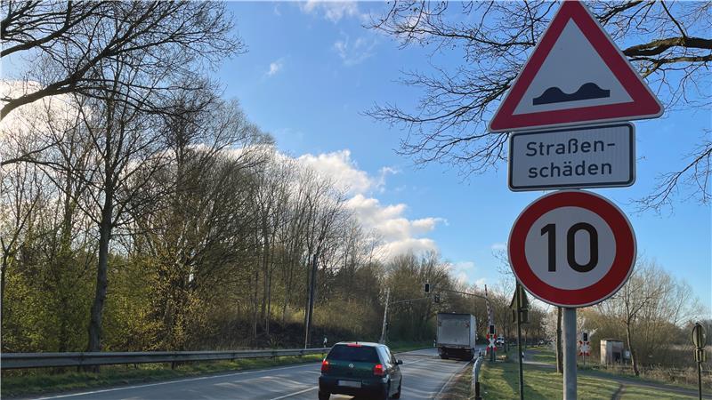 An der Buxtehuder Straße stehen die Verkehrschilder für Straßenschäden und für eine zulässige Höchstgeschwindigkeit von 10 km/h.