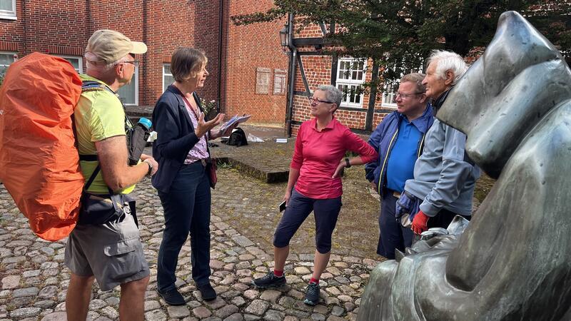 Über 100 Tage Wandern: Bettina Wiebe geht von Stade nach Rom Am Denkmal des Abts Albert in Stade schickt Streckenpatin Sigrid Strüber (Zweite von links) Gilbert Keiser, Bettina Wiebe, Tönnies Kohrs und Lorenzo Cesana (von links) auf den Weg.