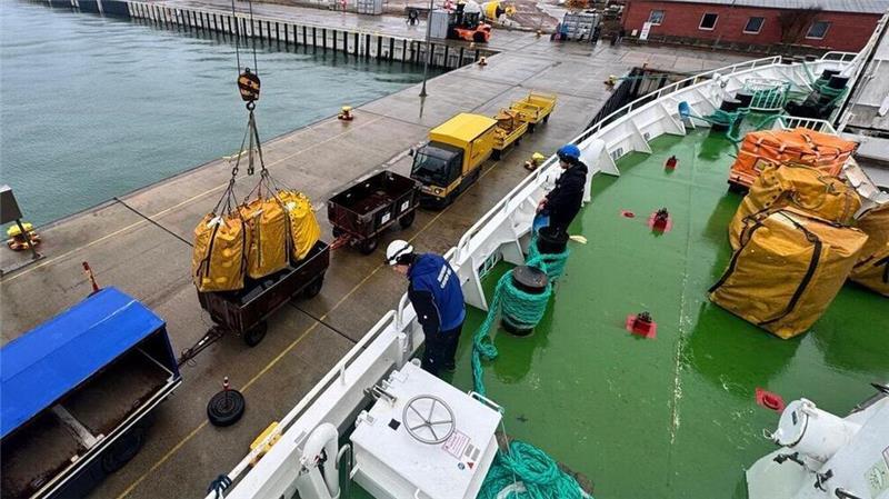 Helgoland bangt um Weihnachtspakete – 1650 Sendungen im Hafen Am Donnerstag sind die nächsten Seesäcke mit Post auf Helgoland angekommen: Die Schiffsbesatzung sorgt dafür, dass die Fracht mit dem Bordkran vorsichtig in die Postwagen gesetzt wird.