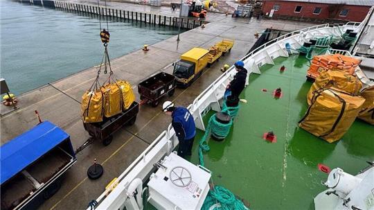 Am Donnerstag sind die nächsten Seesäcke mit Post auf Helgoland angekommen: Die Schiffsbesatzung sorgt dafür, dass die Fracht mit dem Bordkran vorsichtig in die Postwagen gesetzt wird. 