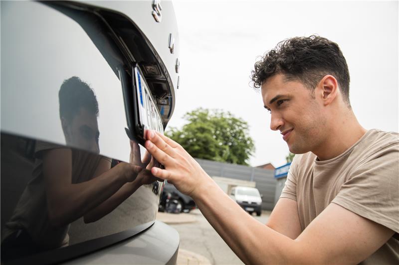 Am Ende gleich: Auch bei der internetbasierten Zulassung müssen Schilder ans Auto geschraubt werden. Foto: Christin Klose/dpa-tmn