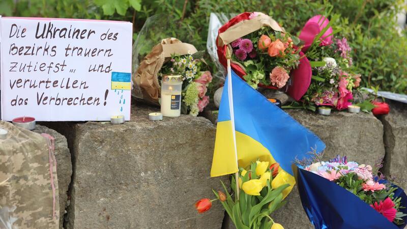 Am Gelände eines Einkaufszentrums, an dem zwei Männer aus der Ukraine getötet worden sind, wurden Blumen niedergelegt sowie eine kleine ukrainische Flagge aufgestellt.