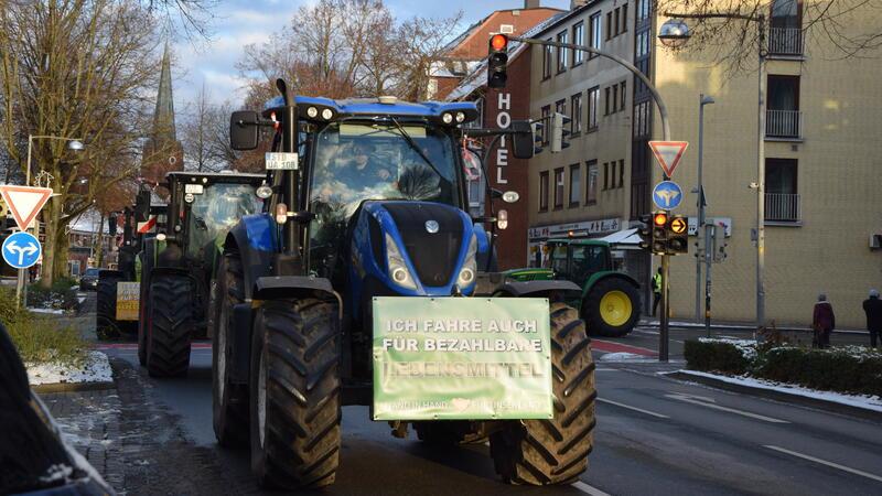 Bauernproteste: Hier dauert es am Donnerstag auf den Straßen im Kreis Stade länger Am Montag fuhren Landwirte auch durch Buxtehude. Auf dem Schild ist zu lesen: „Ich fahre auch für bezahlbare Lebensmittel“