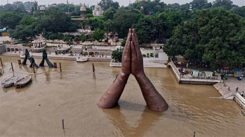 Am Namo Ghat am Ufer des Ganges in Varanasi  ragen die Hände einer riesigen Skulptur aus dem Wasser. Der Wasserstand ist nach den Monsunregenfällen angestiegen.