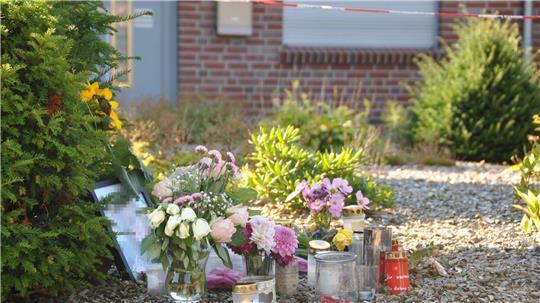 Am Sonntag stehen viele Blumen und Kerzen vor dem Haus in Gyhum am Hülsenbusch. Auch ein Foto der getöteten 30-Jährigen ist zu sehen, die Anteilnahme ist groß. 