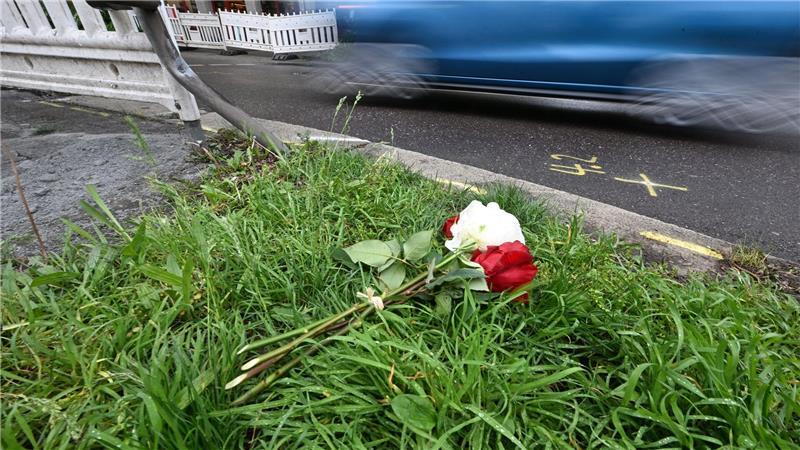 Am Tag nach dem Unfall liegen Rosen am Straßenrand. 