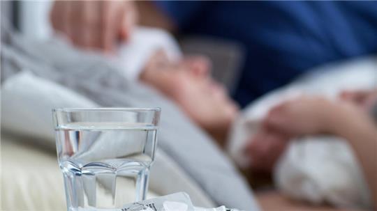 Am besten nicht mit eiskaltem Wasser: Schmerztabletten werden dann nämlich langsamer im Körper transportiert.