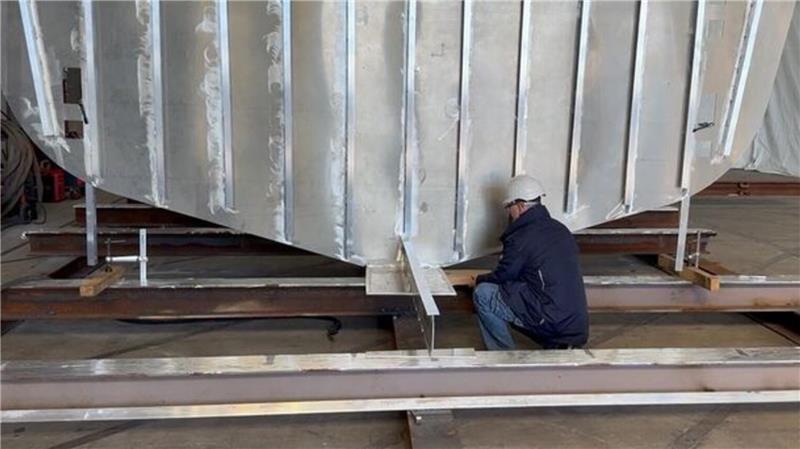 Ampereship-Mitarbeiter Michael Laß positionierte unter der Kiellegungssektion der neuen Helgoland-Fähre das traditionelle Kiellegungsbrett mit Münze.