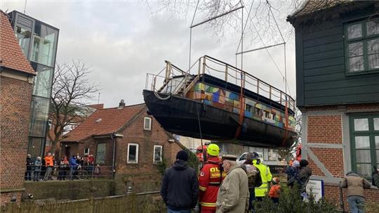 An beiden Seiten des Wassers wird das Einsetzen der Schute gebannt verfolgt.