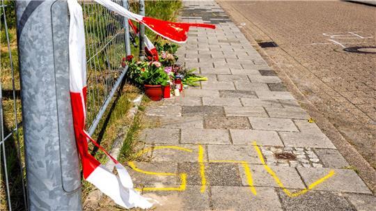 An dem Tatort in einer Wohngegend in Varel liegen inzwischen Blumen und Kerzen.