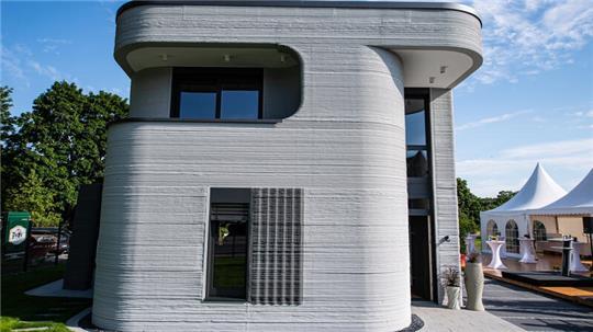 An der Außenfassade sind die mittels eines 3D-Betondruckers aufgetragenen Schichten zu erkennen. Die PERI GmbH druckte im nordrhein-westfälischen Beckum das erste Wohnhaus Deutschlands.