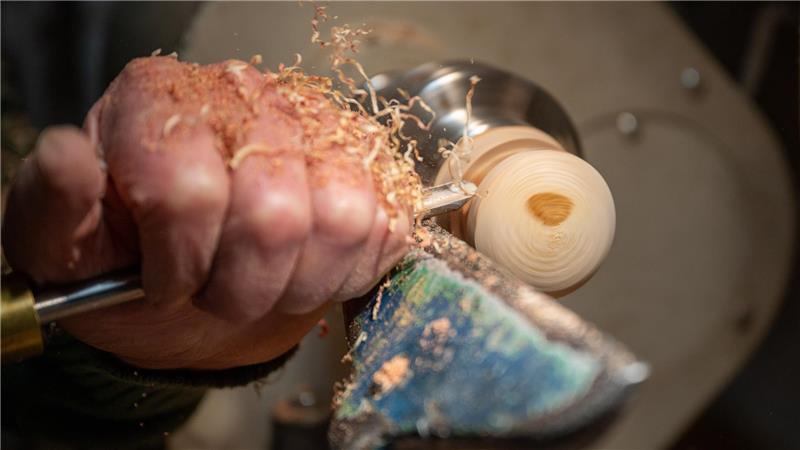 An der Drehbank im heimischen Keller meißelt Claus Wilhelm, einst Fernmeldetechniker, aus Stückchen toten Holzes, oft von Pilzbefall gezeichnet, zu formvollendet schönen Handschmeichlern, Kugeln und Gebrauchsgegenständen. Hier arbeitet er an einem Stück Wacholderast. Foto: Lothar Scheschonka