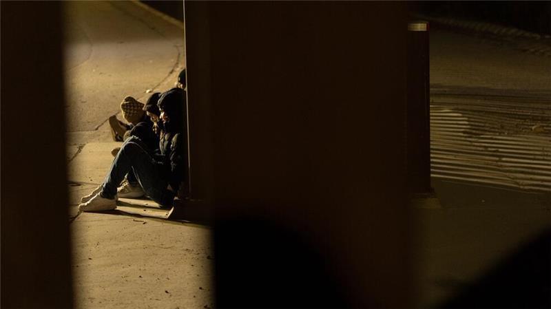 An der Grenze USA/Mexiko: Eine Gruppe von Migranten wartet auf die Abfertigung zwischen den Grenzmauern, die Mexiko und die Vereinigten Staaten trennen, nachdem sie vor Sonnenaufgang illegal die Grenze überquert haben.