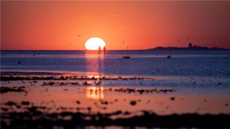 Volle Strände, Städte und Freibäder – doch Hitze bald vorbei An der Nordseeküste lässt sich auch der Abend bei einem Wattspaziergang dieser Tage noch angenehm gestalten. Foto: Arnd Hartmann