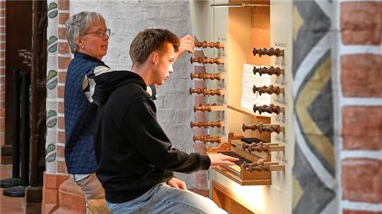 Ein junger Orgelentdecker sitzt neben Kreiskantorin Sybille Groß auf der Bank der neuen West-Orgel in St. Petri.