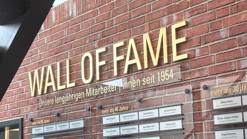 An der Wall of Fame werden langjährige Mitarbeitende verewigt: Ab jetzt kommen immer am 1. September neue dazu, manche Schilder müssen umgehängt werden.