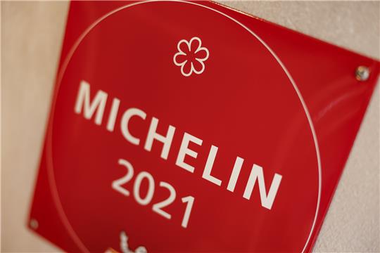 An der Wand eines Restaurants hängt ein Schild, welches deutlich macht, dass das Lokal im Jahr 2021 mit einem Michelin-Stern ausgezeichnet worden war.  Foto: Daniel Löb/dpa