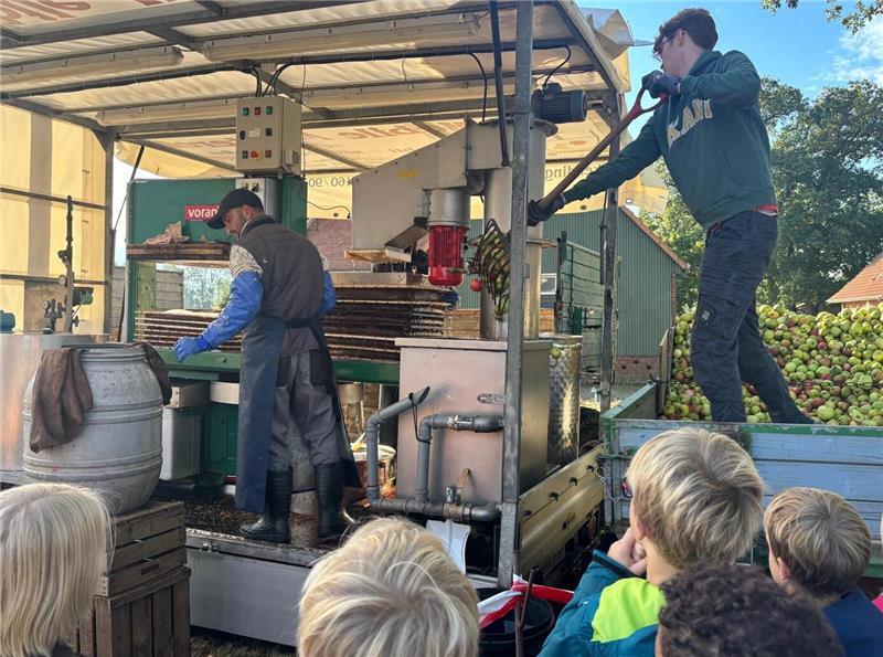 Ahlerstedter Kinder helfen: Wenn tonnenweise Äpfel zu Saft werden An der mobilen Mosterei werden Äpfel gepresst: Die Schülerinnen und Schüler schauten aufmerksam zu.