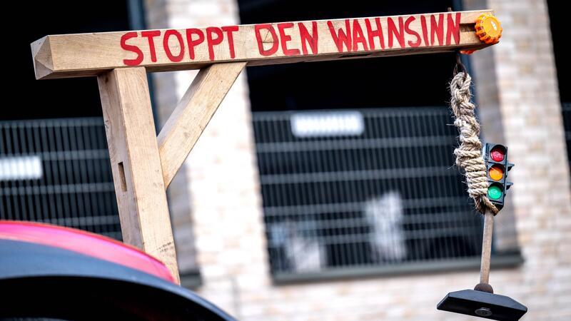 Polizei: Verkehrsbehinderungen in Bremen nehmen ab An einem Traktor ist bei einer Demonstration von Bauern ein Galgen befestigt, an dem eine Ampel hängt.