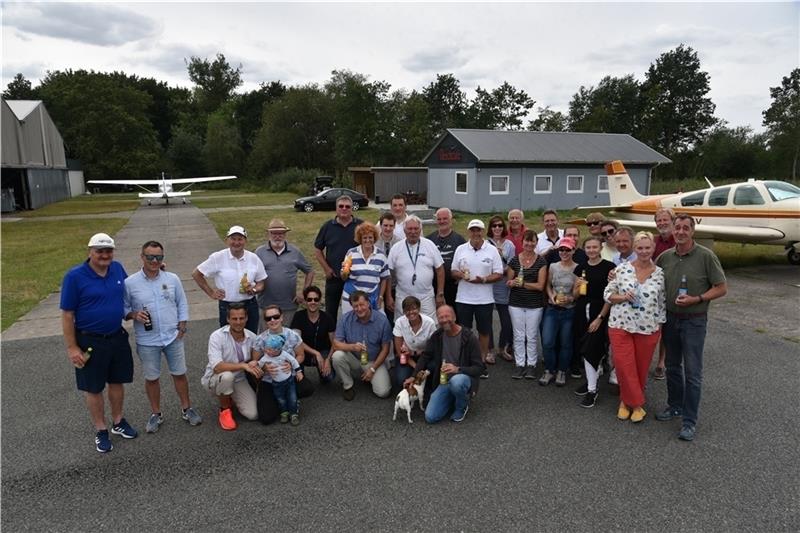 Andrang auf dem Stader Flugplatz: Vereinsmitglieder und Gäste stoßen mit alkoholfreien Getränken auf das neue „Beechcafé“ (im Hintergrund) an. Foto: Beneke